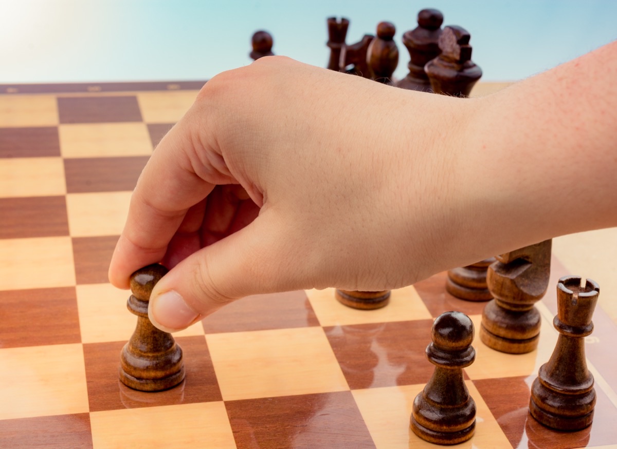 Hand moving a piece on a chessboard