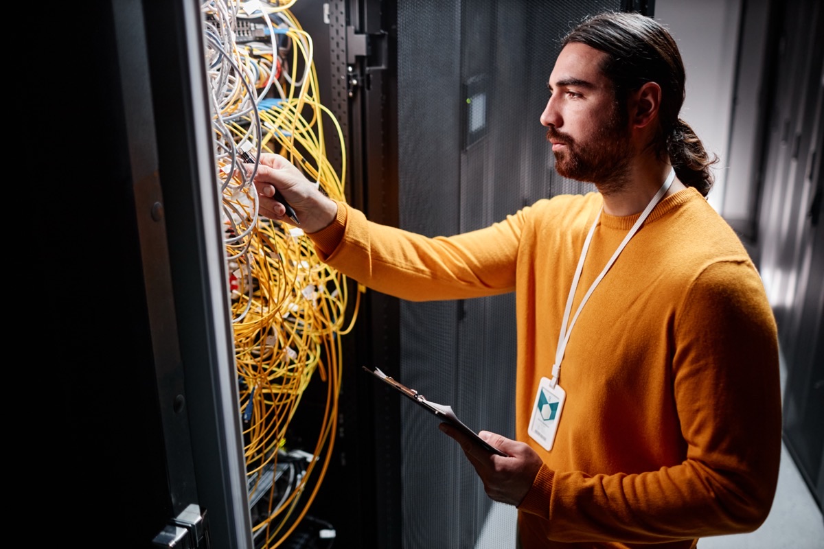Technician connecting cables in a server rack